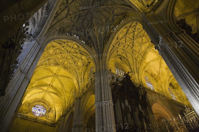 Architectural details on ceiling and stained glass rose window in Interior of The Cathedral of Saint Mary of the See or Seville Cathedral, Seville, Spain, Europe