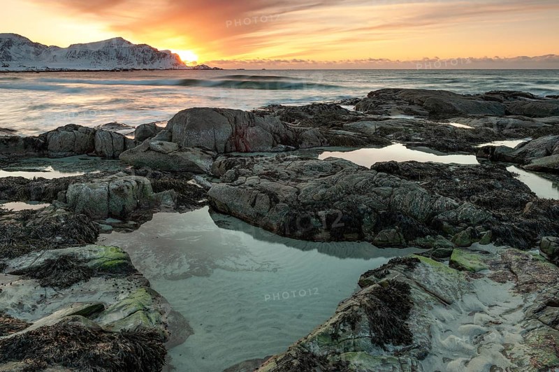 Sunset in winter at Skagsanden, rocks on the beach at Flakstad, Flakstadøy, Lofoten, Nordland, Norway, Europe