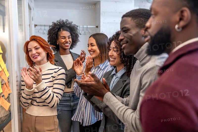 Diverse teamwork applauding at the end of a brainstorming meeting in a coworking space