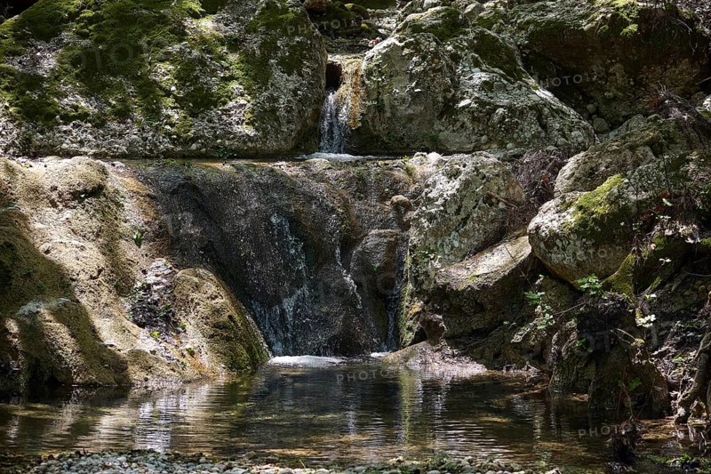 Small waterfall flows over moss-covered rocks in a forest, Butterfly Valley, Butterfly Valley, Rhodes, Dodecanese, Greek Islands, Greece, Europe