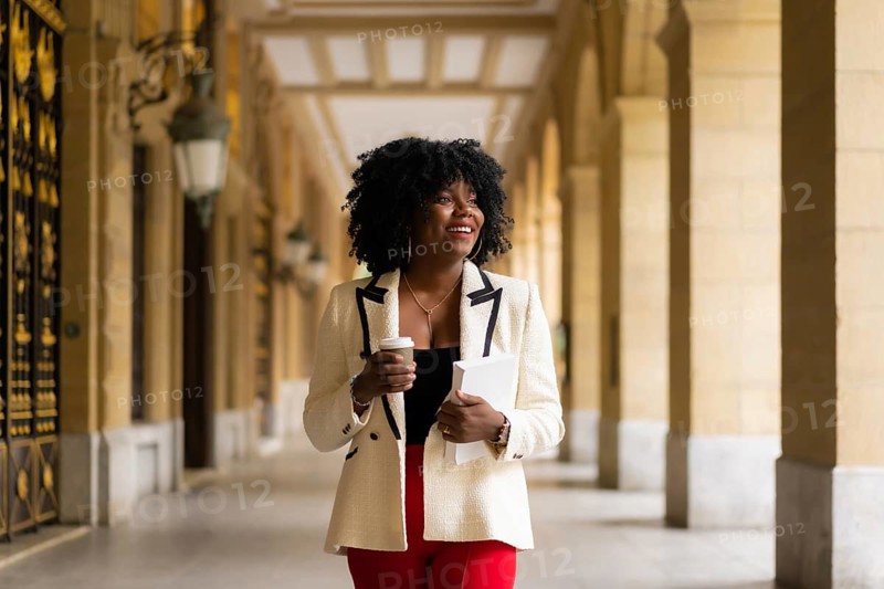 Elegant african american businesswoman walking in the city street in the morning