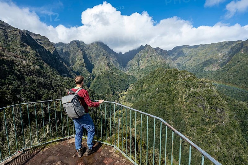 Tourist at a viewpoint, view from the Miradouro dos Balcões, densely overgrown steep mountains, green mountain landscape, mountain valley Ribeira da Metade and the central mountains, Madeira, Portugal, Europe