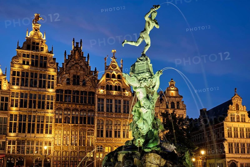 Antwerp famous Brabo statue and fountain on Grote Markt square illuminated at night and old houses. Antwerp, Belgium, Europe