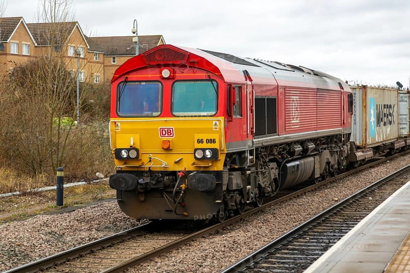 DB Cargo Class 66 freight train passing through Peterborough railway station, Cambridgeshire, England, UK