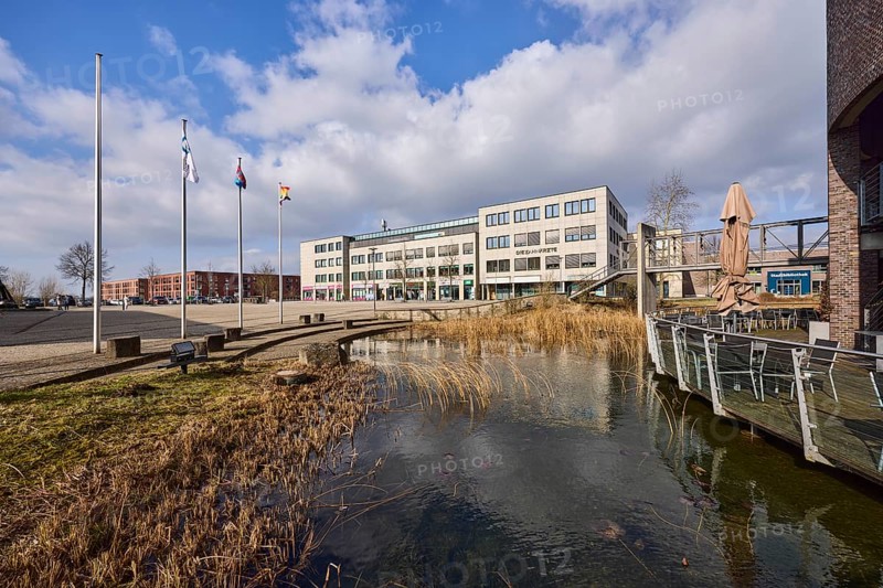 Rathausterassen Garbsen, outdoor area of a restaurant, pond, lawn, flagpoles, commercial buildings, city trees, blue sky with cumulus clouds, town hall square, Garbsen, Hanover region, Lower Saxony, Germany, Europe