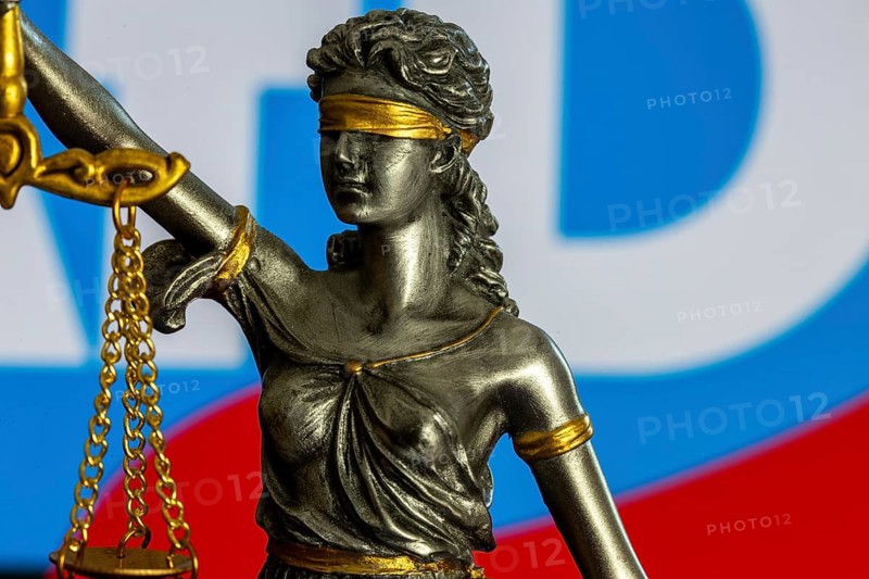 Justitia in front of the AfD logo (symbolic image) . The Office for the Protection of the Constitution has categorised the AfD as right-wing extremist. The AfD wants to take legal action against this