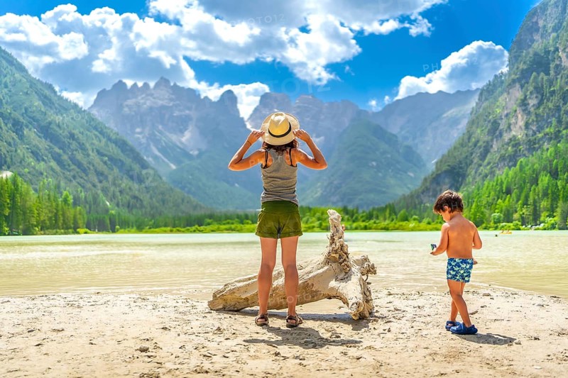 Mother and son enjoying a sunny day at lago di landro, surrounded by the stunning dolomites in south tyrol, italy