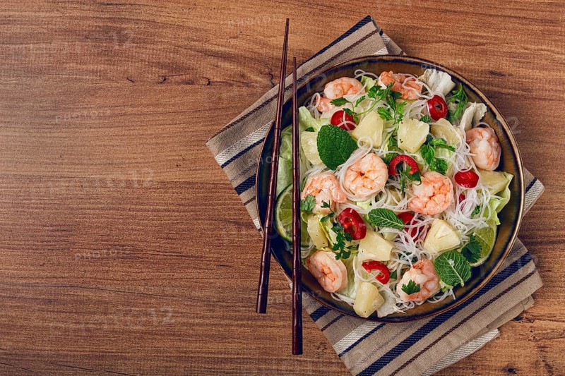 Thai salad with shrimp and rice noodles, pineapple slices, coriander and mint leaves, homemade, no people
