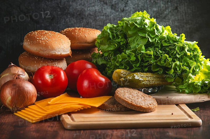 Fresh ingredients for a hamburger, such as lettuce, tomatoes, cheese and bun