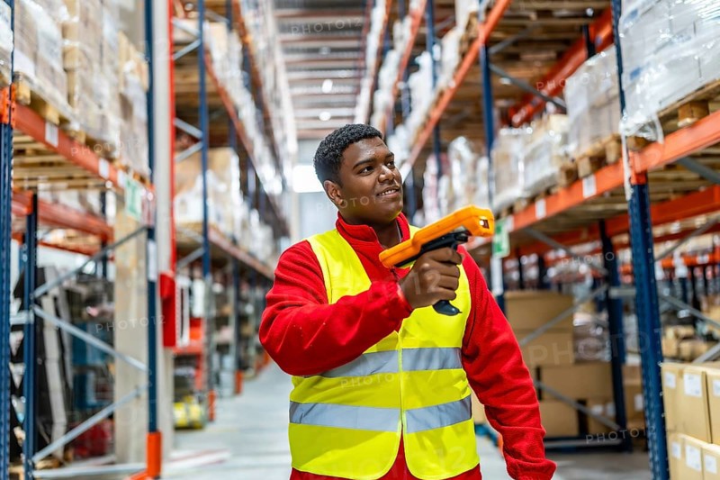 Latin male warehouse worker using bar code scanner to analyze newly arrived goods for further placement in storage department