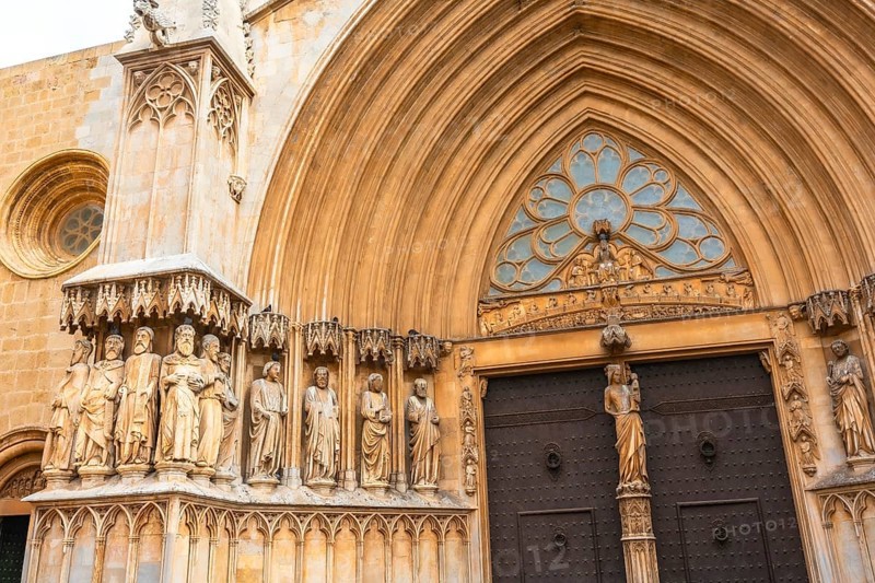 Statues of saints decorating the richly adorned main entrance of tarragona cathedral, a stunning example of gothic and romanesque architecture