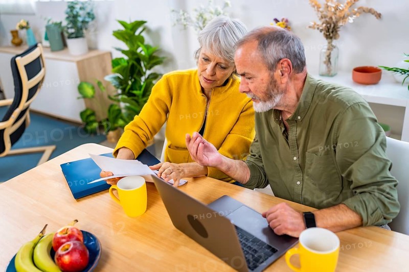 Elevated view of a caucasian senior couple doing the household accounting with laptop