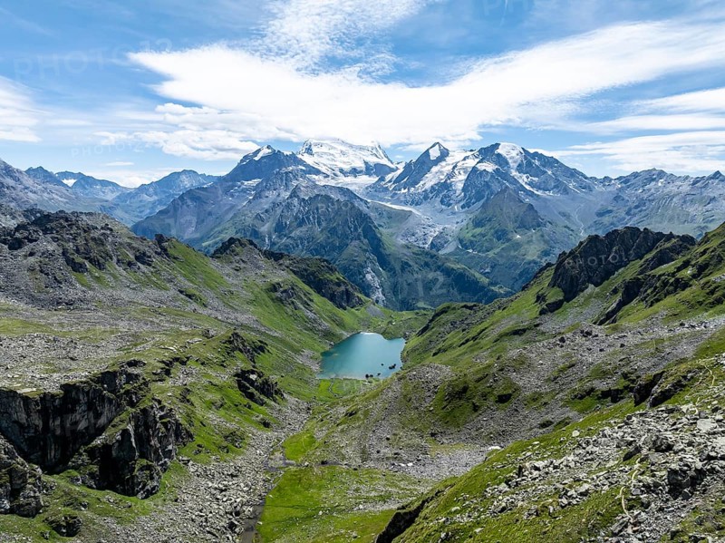 Mountain stream and mountain lake Lac de Louvie with glaciated summit of the Grand Combin, Val de Bagnes, Valais, Switzerland, Europe