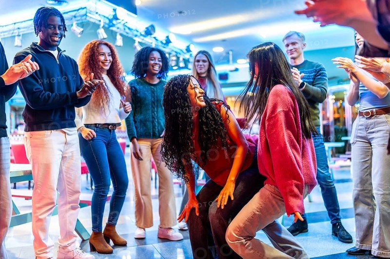 Young people having fun dancing at the bowling alley, enjoying their weekend together with energy and enthusiasm