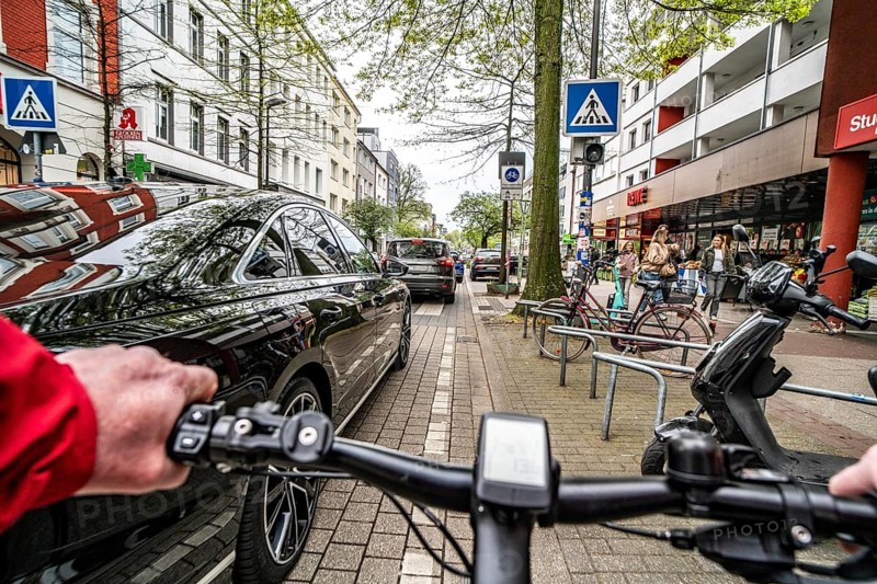 Cycling in the city, inner-city street, cycle lane, bicycles have priority, two-lane traffic with parked cars on both sides, cyclists' perspective, Essen, North Rhine-Westphalia, Germany, Europe