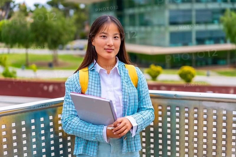Three quarter length portrait of a beauty female asian student standing proud outside the university