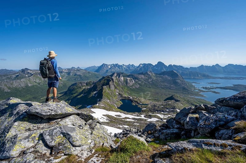 View of mountain landscape, mountain panorama, mountaineer at the summit of Rundfjellet, lake Hellskarvatnet, Svolvaer, Nordland, Norway, Europe