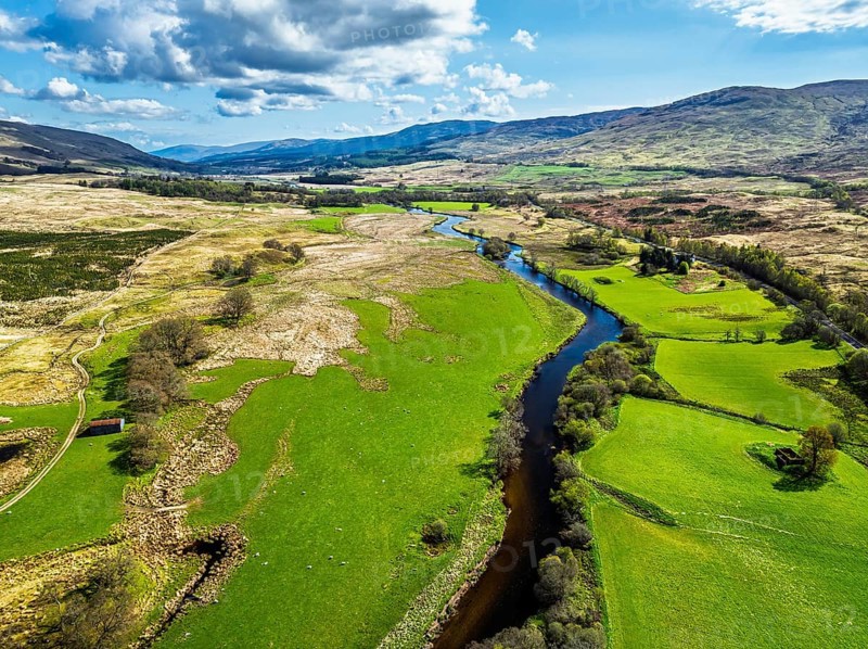 Farms and Mountains over River Dochart and Road A85 from a drone, Perthshire, Scotland, UK