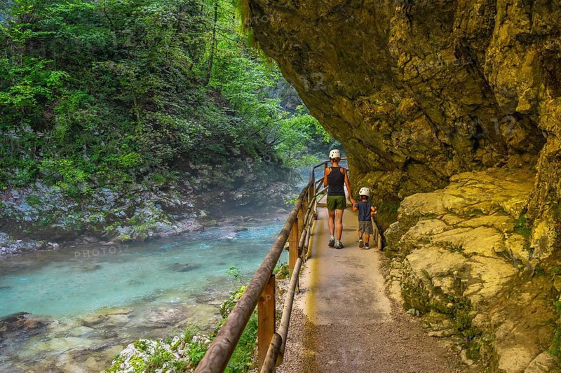 Tourists walking along the radovna river in vintgar gorge, near bled, slovenia, enjoying the stunning scenery and peaceful surroundings