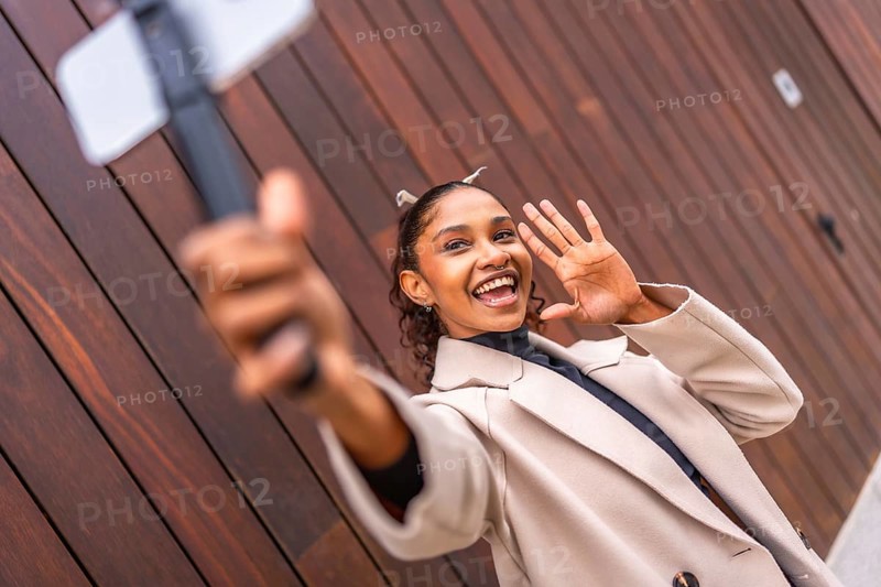 African american young female Content creator recording a new vlog using phone in the city