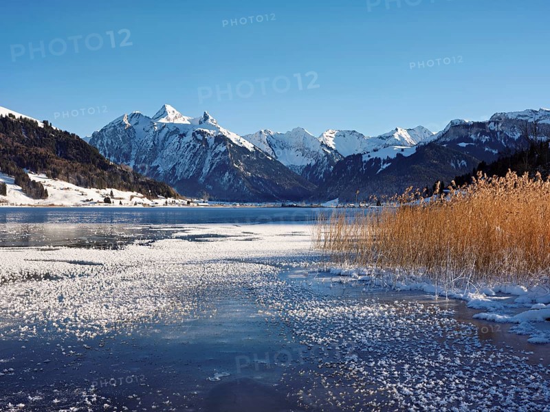 Frozen Sihlsee, reservoir, behind the snow-covered mountains Flübrig and Druesberg, Euthal, Canton Schwyz, Switzerland, Europe
