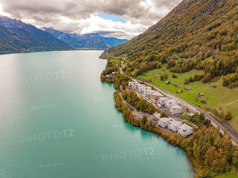 Lake with neighbouring buildings on the mountain slopes under a cloud cover, Lake Brienz. Switzerland