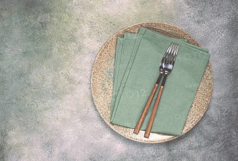 A plate with a kitchen towel and two forks, food wallpaper, food concept, top view, no people