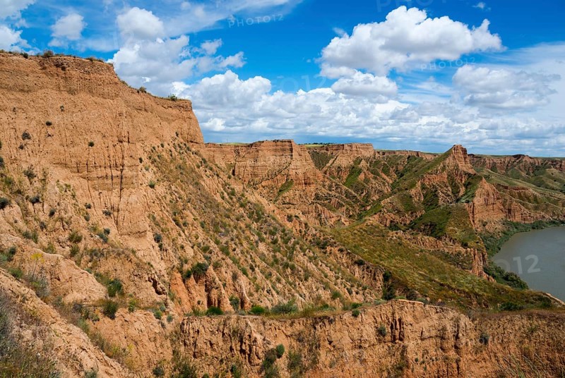 Ein felsiger Canyon mit einem klaren blauen Himmel und weißen Wolken darüber, Barrancas de Burujón, Burujon, río Tajo, Fluss Tajo, embalse de Castrejón, Stausee de Castrejon, Toledo, Kastilien-La Mancha, Spanien