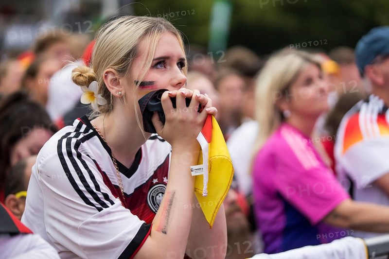 A woman watches the football match in the fan zone at the Brandenburg Tor during the quarter-final match between Germany and Spain at the European Football Championship, Berlin, 05/07/2024