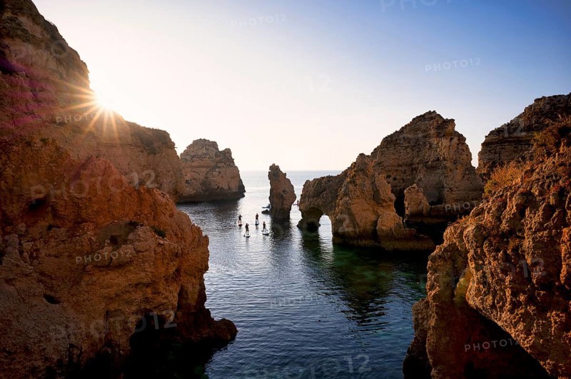 Stand up paddlers on their boards, kayakers, colourful cliffs and sunrise, rocks in the sea, Ponta da Piedade, Lagos, caves, cliffs, Atlantic Ocean, Algarve, Portugal, Europe