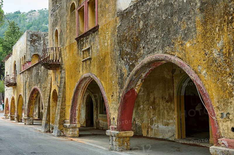 Street with dilapidated yellow historic-style buildings characterised by arches, balconies and peeling plaster, Italian Governor's Palace, Ruins, Italian colonial settlement, Eleousa, Rhodes, Dodecanese, Greek Islands, Greece, Europe