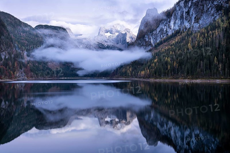 The Vordere Gosausee lake in autumn with a view of the Dachstein mountain range. The Gosaukamm on the right. Blue sky and clouds. In the evening after sunset. Reflection. Vorderer Gosausee, Gosau, Gosau valley, Salzkammergut, Upper Austria, Austria, Europe