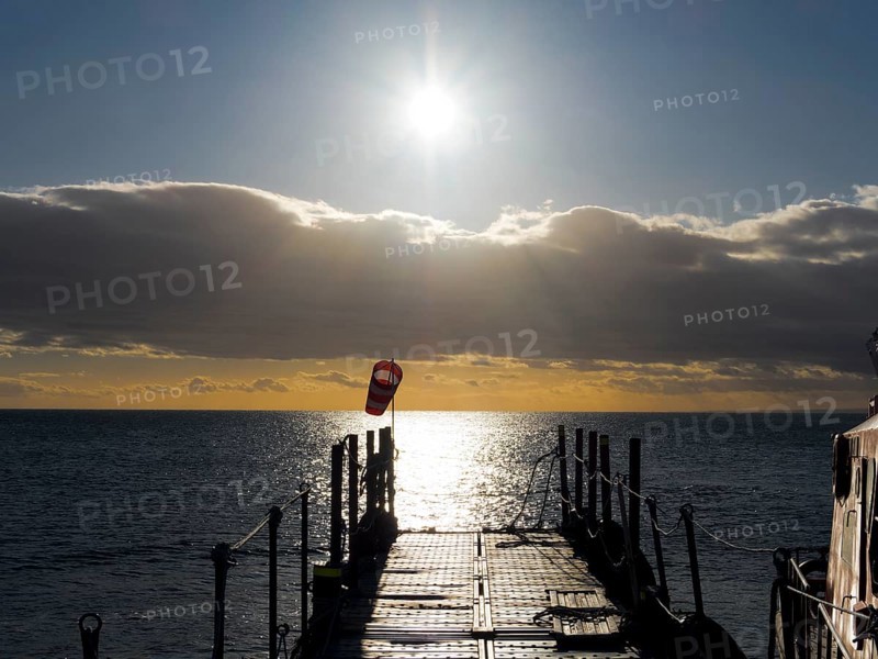 Jetty at sunrise over the sea on the Strait of Magellan, Punta Arenas, Chile, South America