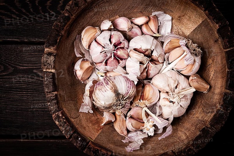 Fresh garlic, in a wooden plate, top view, close-up, no people