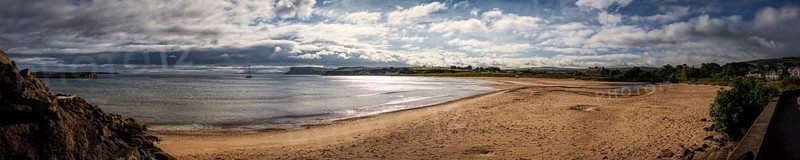 Extensive sandy beach overlooking the sea, cloudy skies and tranquil natural scenery, Ballycastle