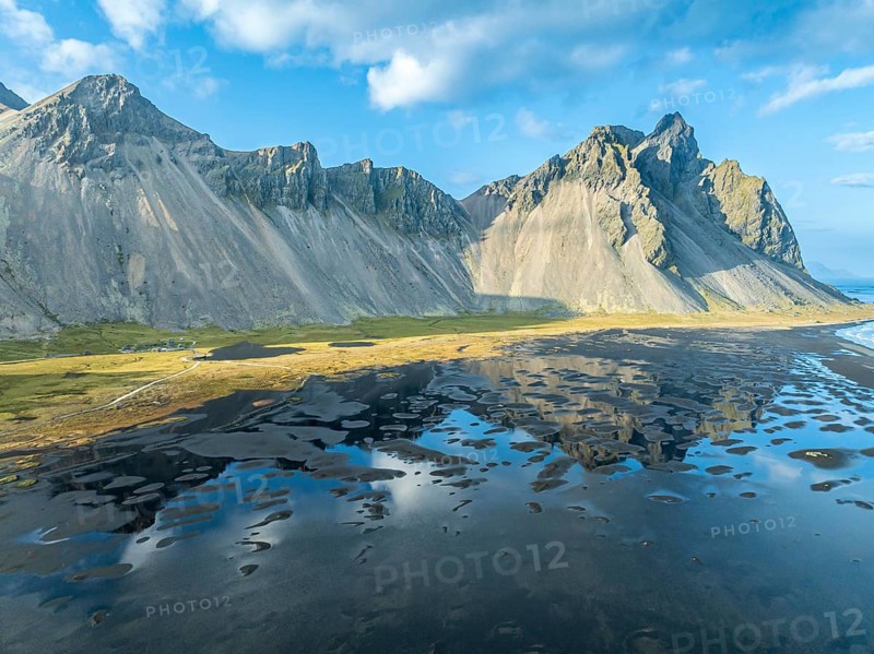 Aerial view of Mt. Vestrahorn, black lava beach, reflections on the water, Stokksnes, east of Höfn, East Fjords, Iceland, Europe
