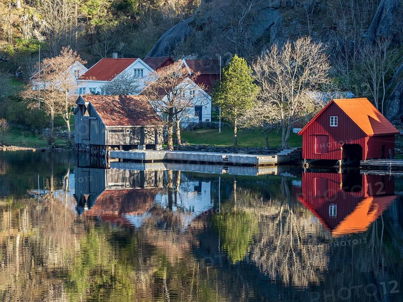 Fjord near Ana Sira at the norwegian southern coast, lonely houses at the foot of a rock formation, Norway, Europe