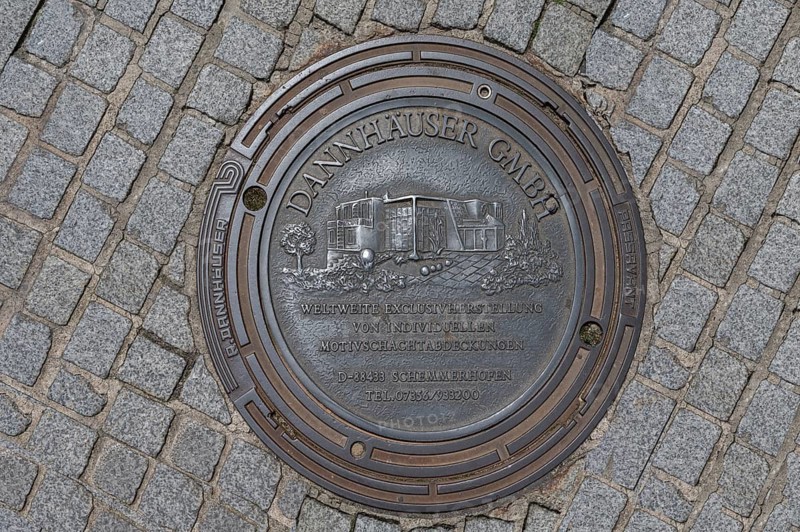 Manhole cover with self-advertising of the manhole cover manufacturer, Bad Kissingen, Lower Franconia, Bavaria, Germany, Europe