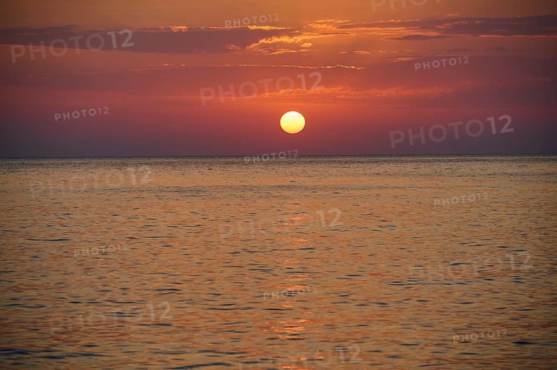 Sunset over the calm sea under an orange sky, Mandraki, Nisyros, Dodecanese, Greek Islands, Greece, Europe