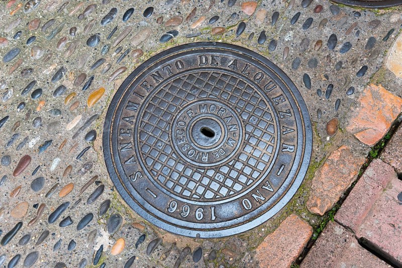 Manhole cover installed in Alquezar in 1966, surrounded by uneven paving stones, manhole cover, manhole cover, Alquézar, Alquezar, Huesca, Aragón, Aragon, Pyrenees, Spain, Europe
