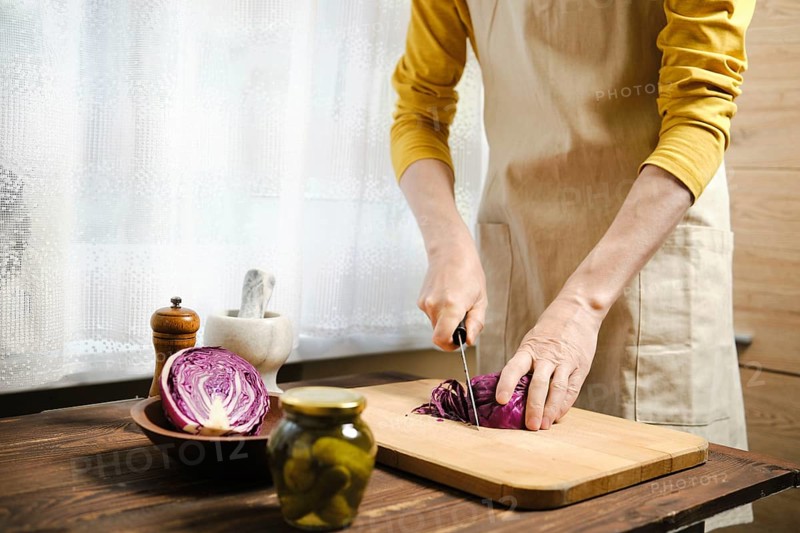 Unrecognizable man cutting purple cabbage in the kitchen
