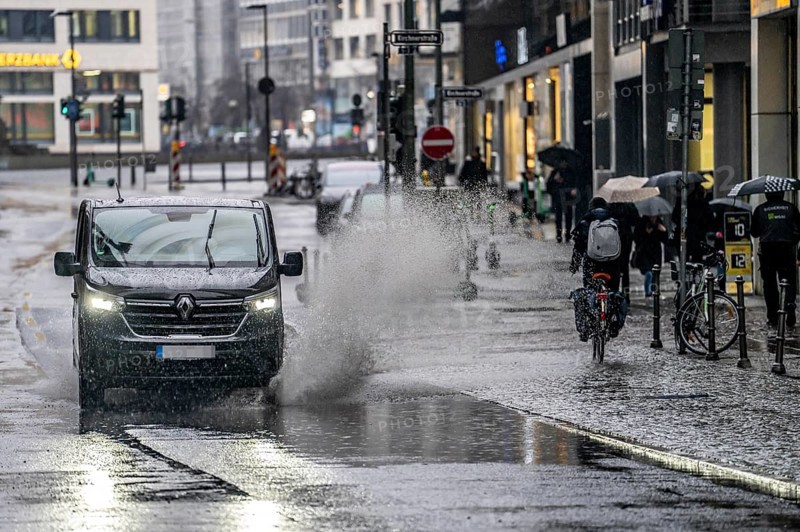 Winter, rainy weather, freezing rain, large puddle, puddle of water, in the city centre, Große Gallusstraße, vehicles driving through, spraying water fountains, Frankfurt am Main, Hesse, Germany, Europe