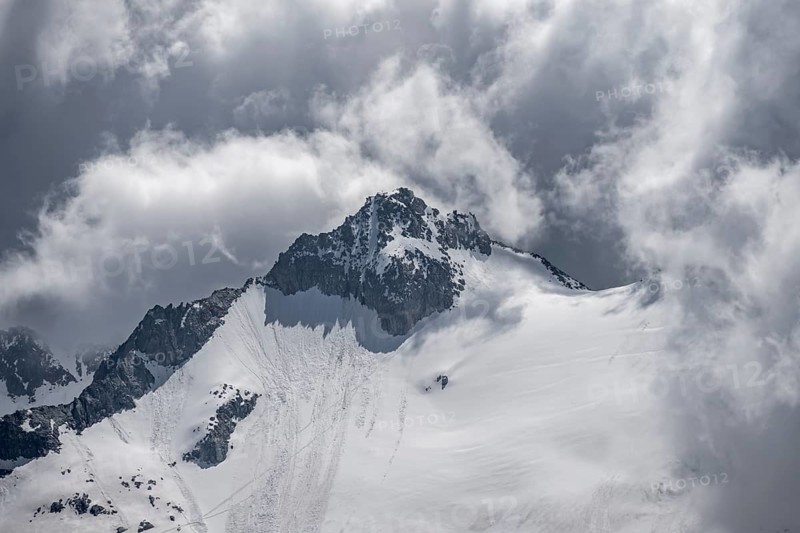 Dramatic clouds, rocky mountain peak with snow and glacier Waxeggkees, Berliner Höhenweg, Zillertal Alps, Tyrol, Austria, Europe