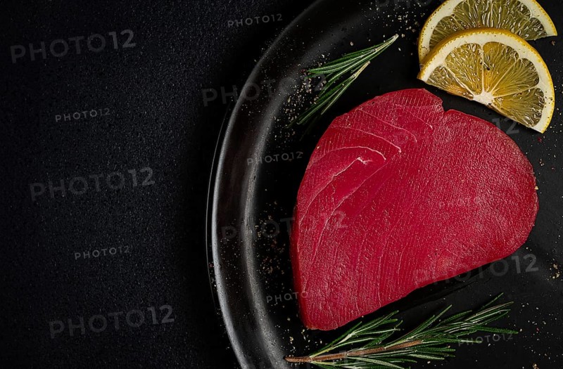 Fresh red tuna fillet, for steak, raw, top view, on a black plate, no people