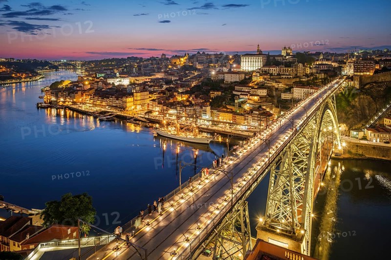 View of illuminated Porto city and Douro river and Dom Luis bridge I from famous tourist viewpoint Miradouro da Serra do Pilar in evening twilight. Porto, Vila Nova de Gaia, Portugal, Europe