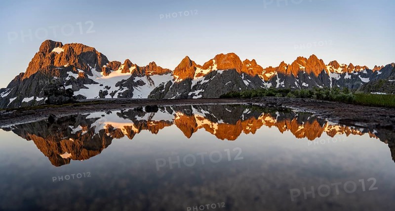 Rocky mountain peaks reflected in a small pond, mountain landscape with alpenglow at sunrise, at the Trollfjord Hytta, at the Trollfjord, Lofoten and Vesterålen, Nordland, Norway, Europe