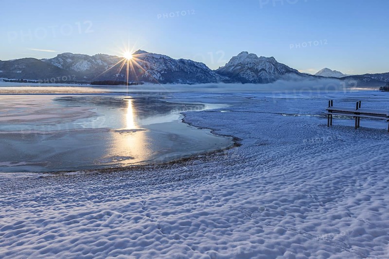 Sunrise at a lake in front of mountains, footbridge, snow, winter, Forggensee, Königswinkel, view of Tegelberg and Säuling, Alpine foothills, Upper Bavaria, Bavaria, Germany, Europe