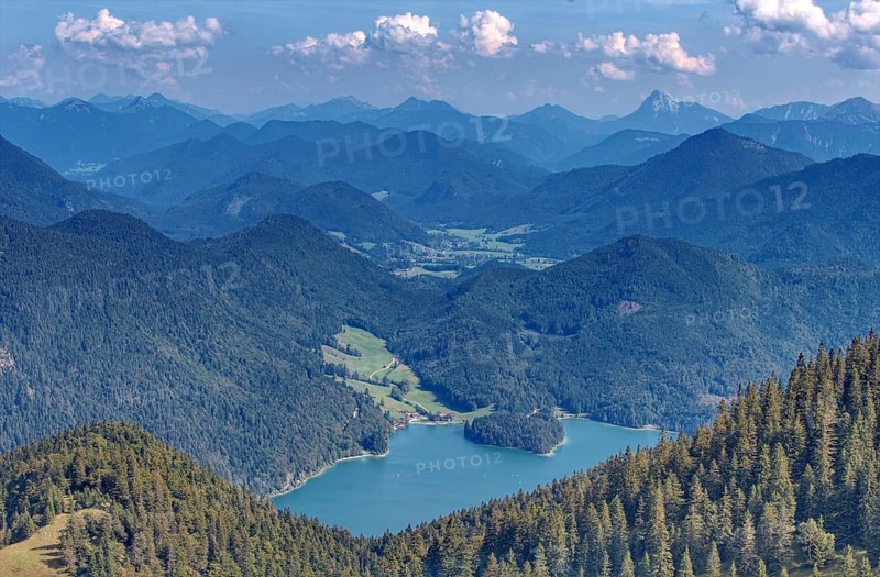 A wide panorama of mountains and valleys with extensive forests under a blue sky with clouds, Walchensee, Bavaria, Germany, Europe