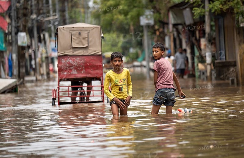 Children wade through a flooded street after heavy rains in Guwahati, India on April 28, 2025