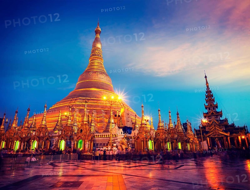 Vintage retro effect filtered hipster style image of Myanmer famous sacred place and tourist attraction landmark, Shwedagon Paya pagoda illuminated in the evening. Yangon, Myanmar Burma